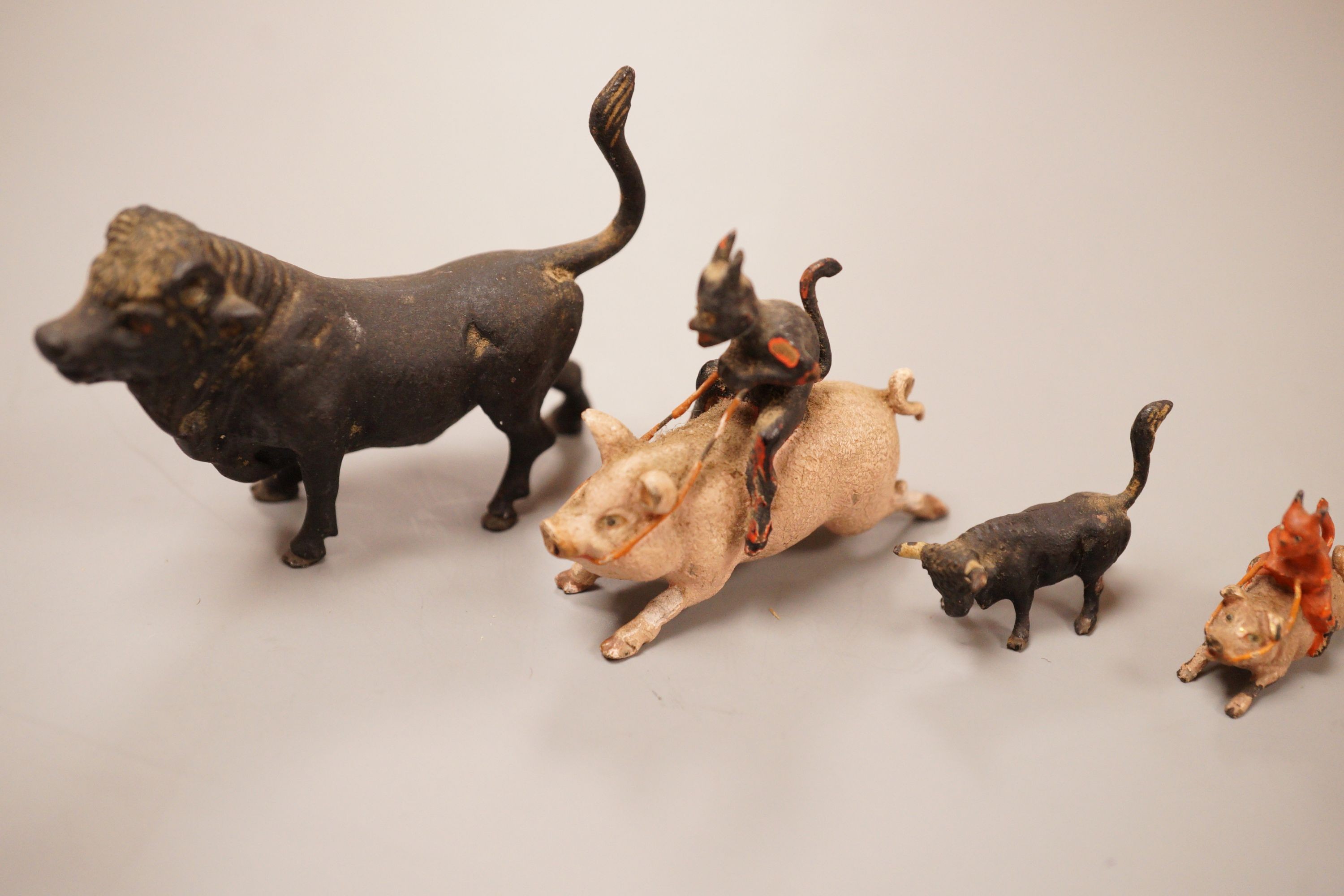 Four Austrian cold painted bronze miniature groups or figures, two of the devil riding a pig and two of cattle, tallest 4cm